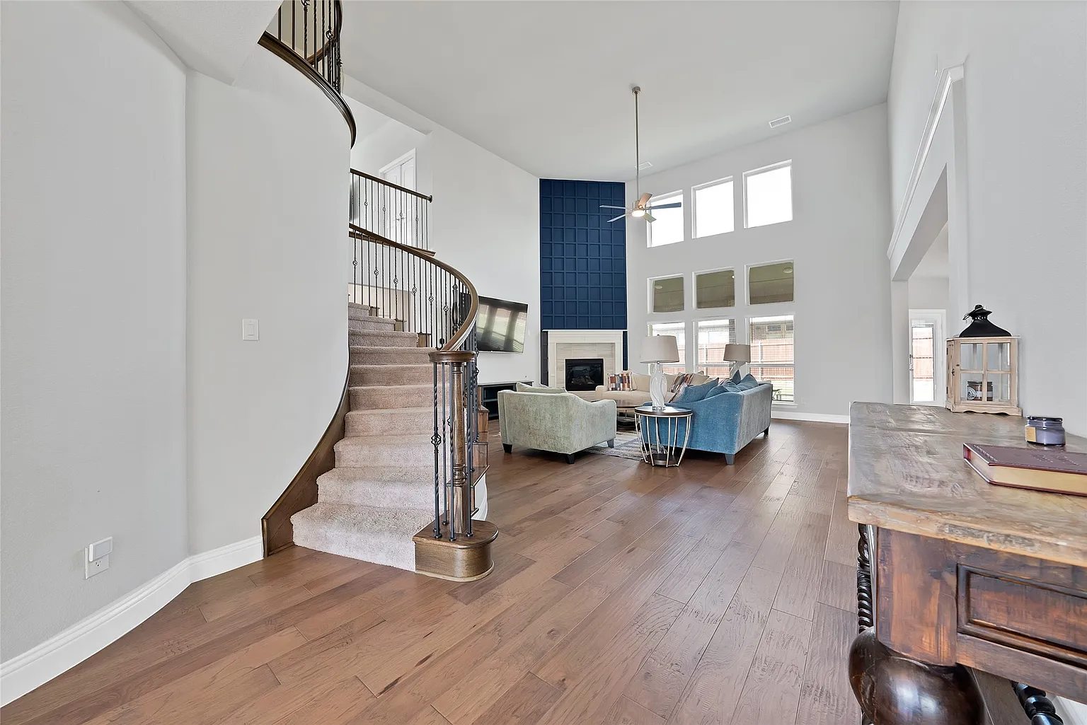 Wood-floored entry and curved staircase leading toward the main living room.