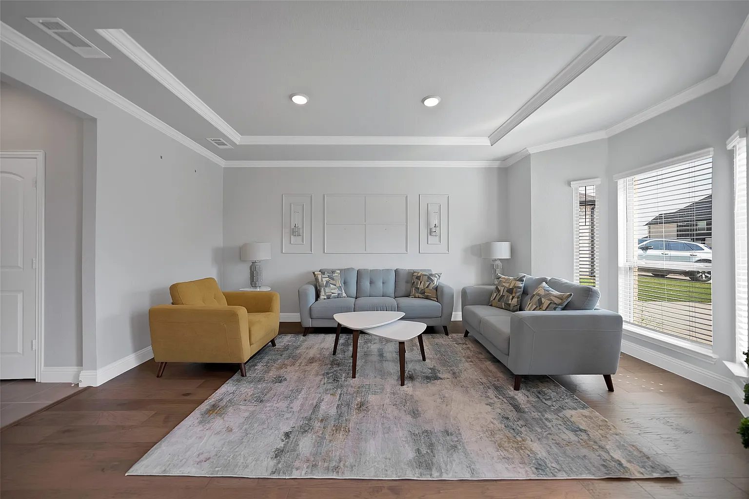 Front sitting area with a tray ceiling and engineered hardwood floors.