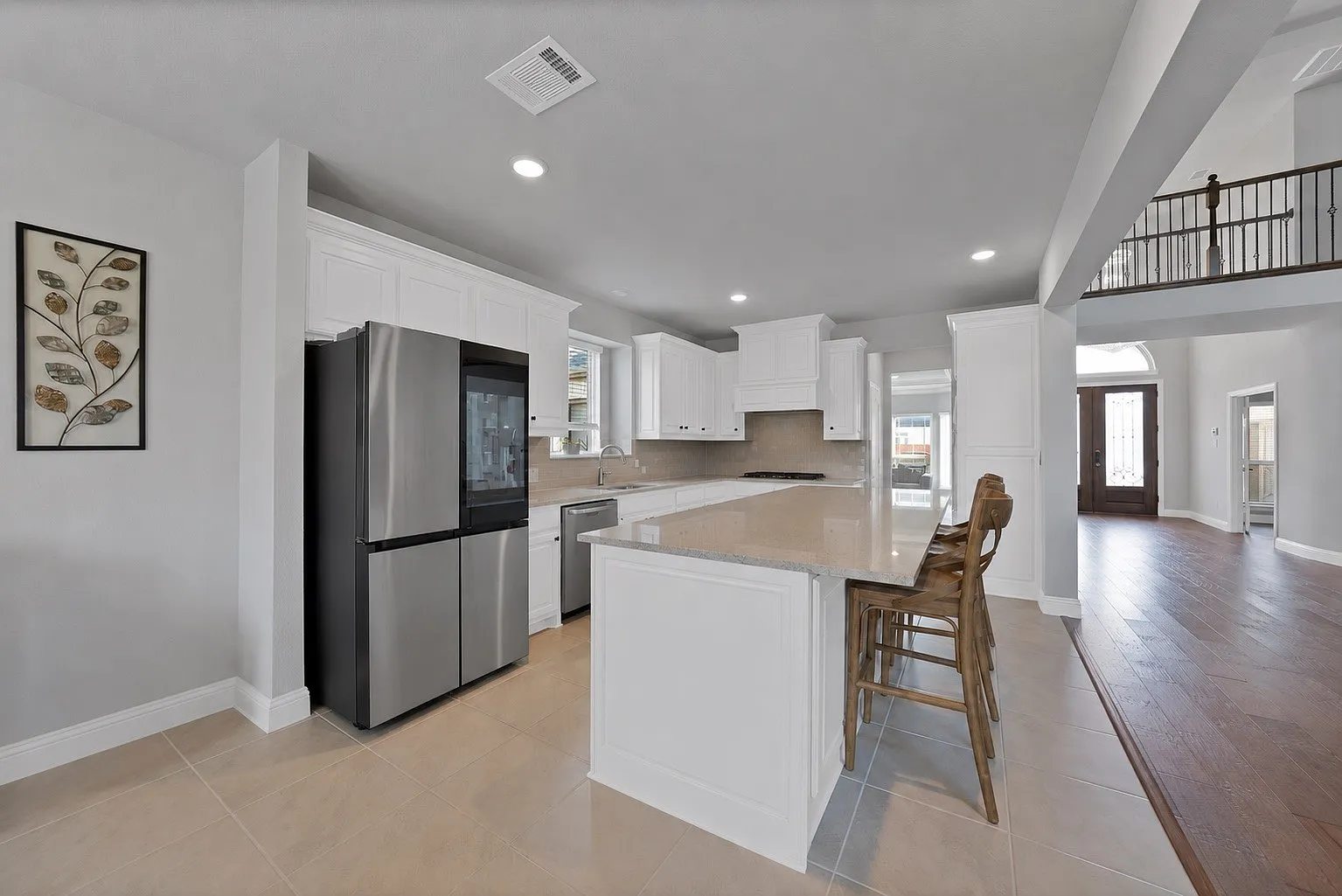 Kitchen island, white cabinets and appliances, looking toward the living area.