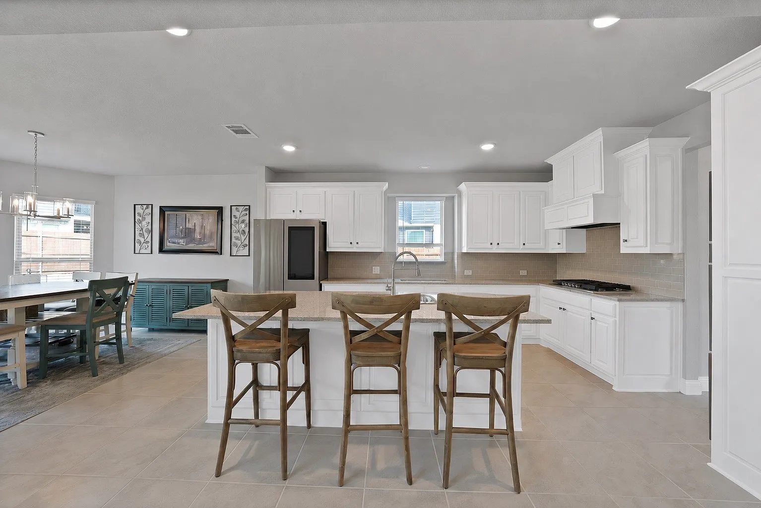 Kitchen with a central island, bar seating and adjacent dining space.