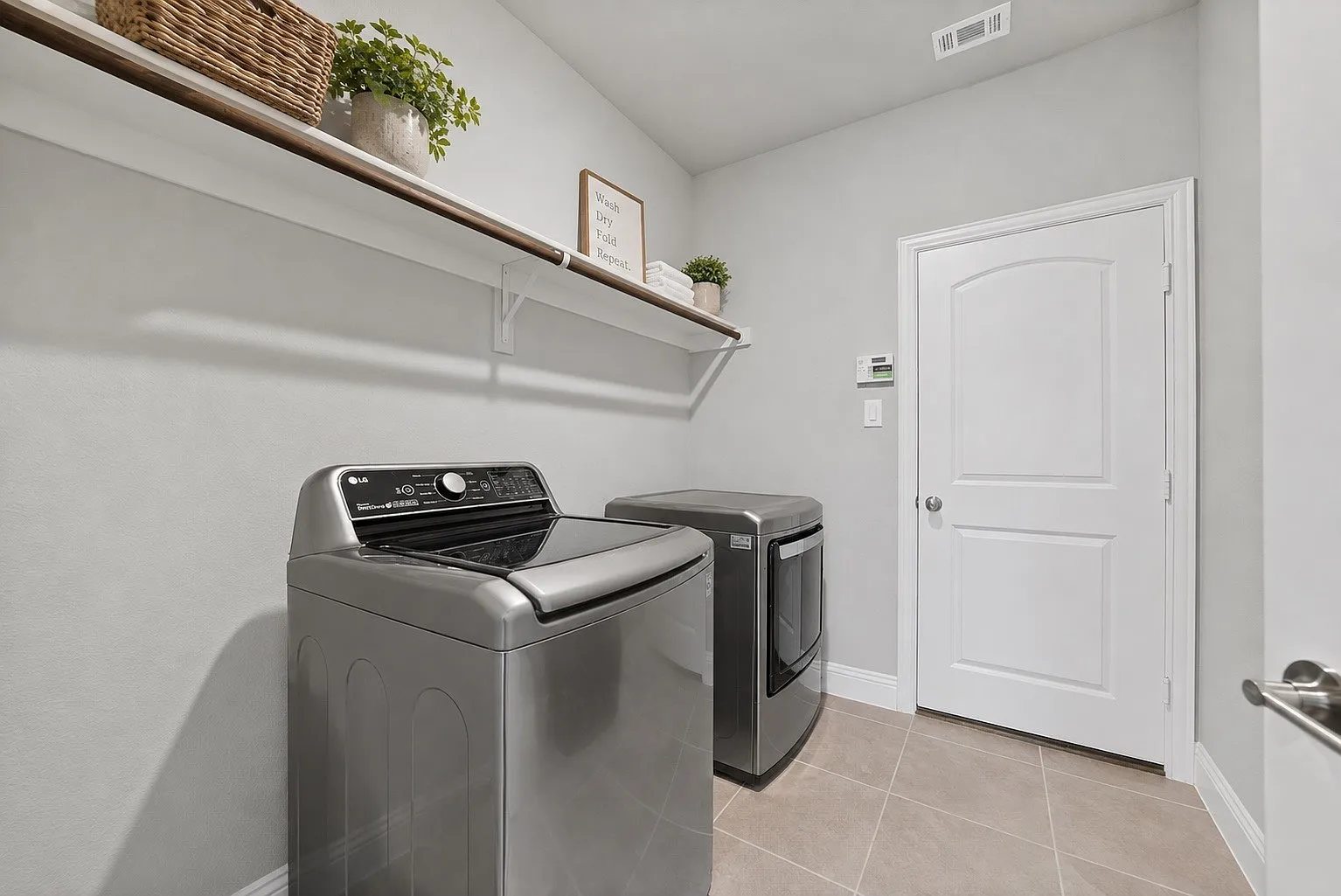 Utility room with laundry appliances and shelving.