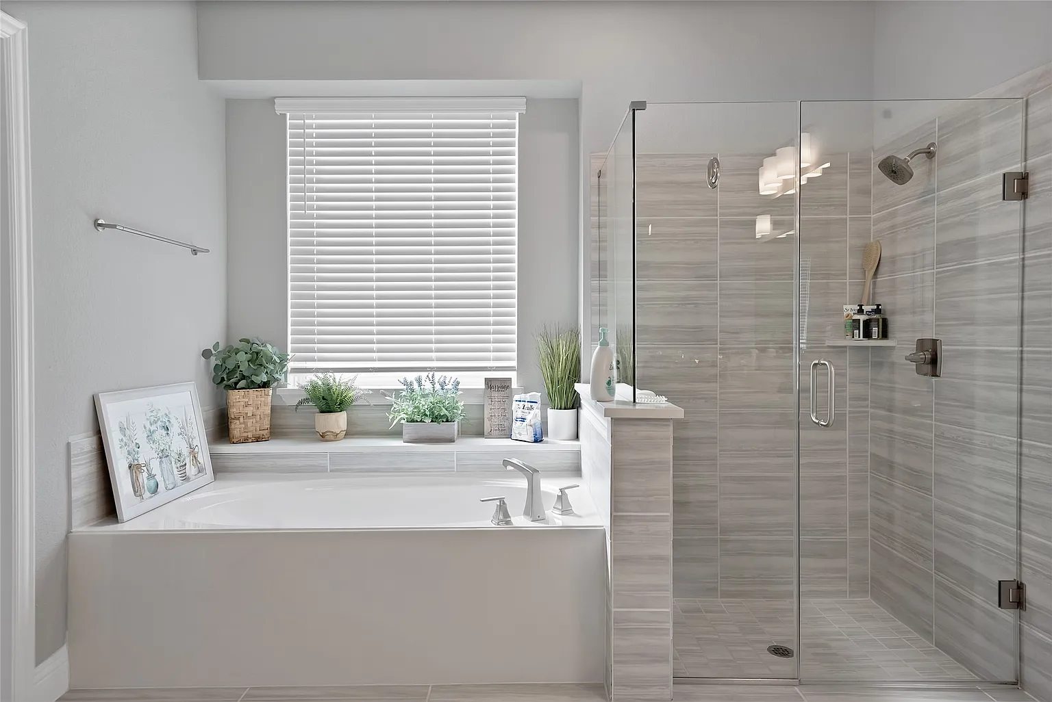 Primary bathroom with a separate tub, window and glass shower.