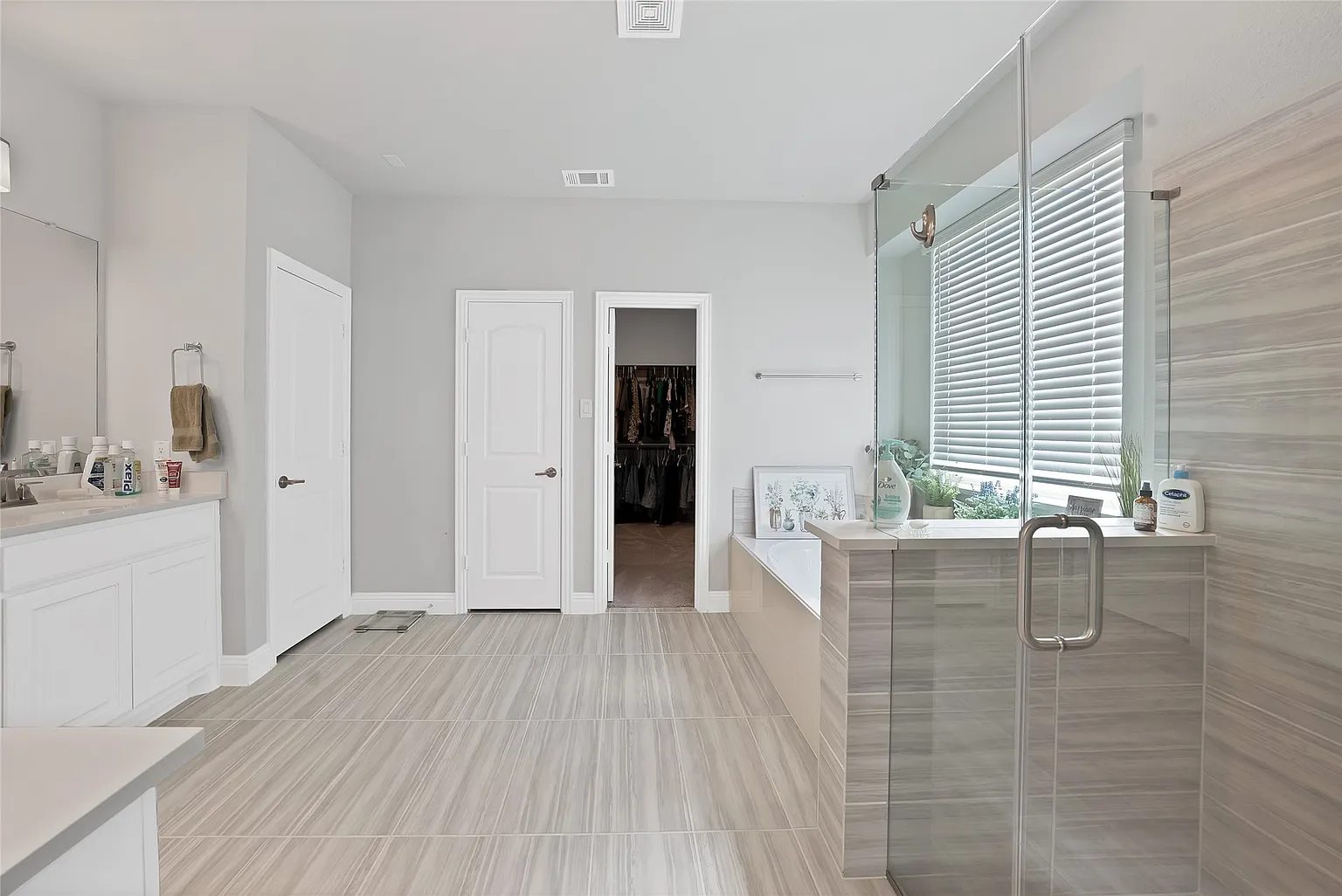 Another view of the primary bathroom toward the bedroom doorway.