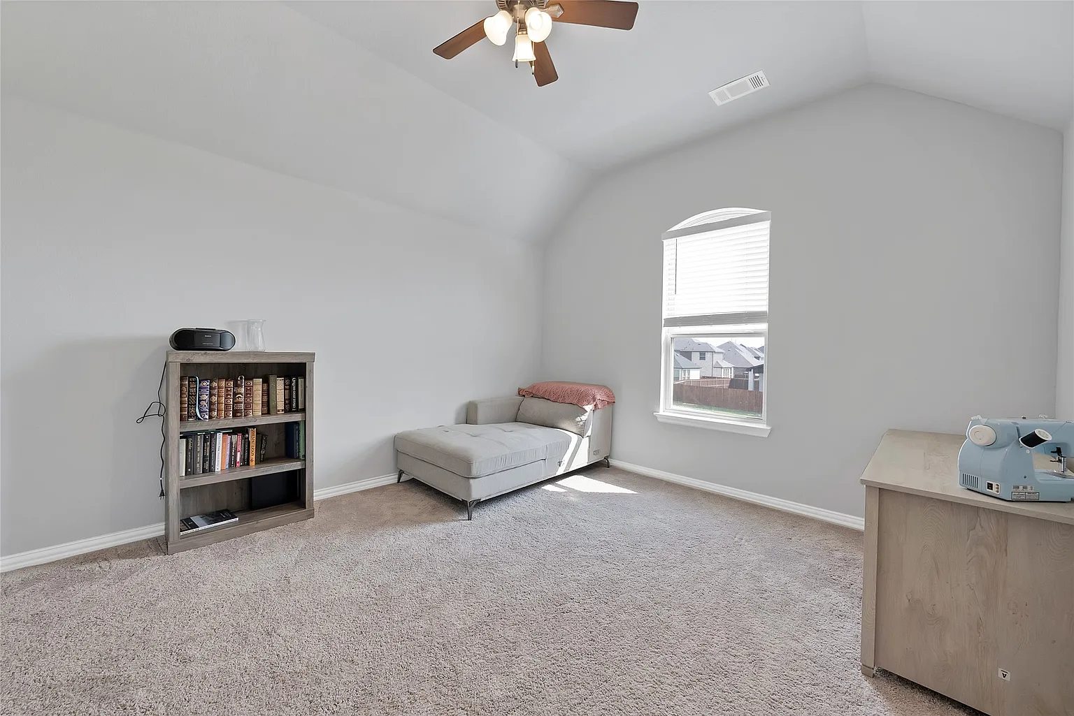 Carpeted bedroom with a window, ceiling fan and single bed.