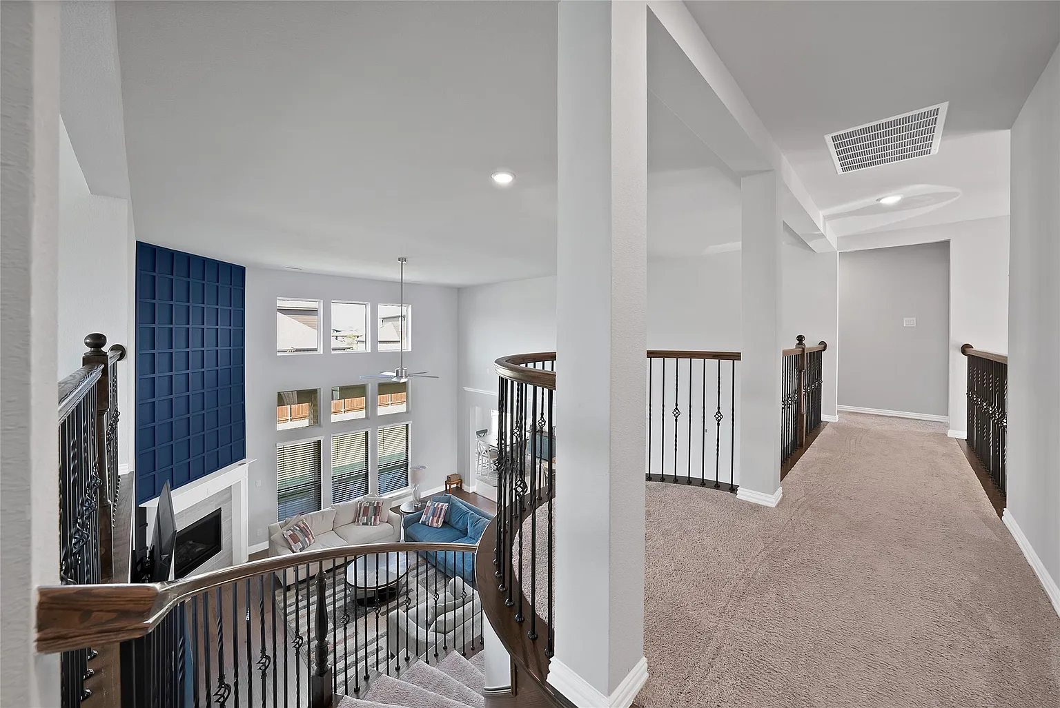 Upstairs landing and railing overlooking the two-story living room.